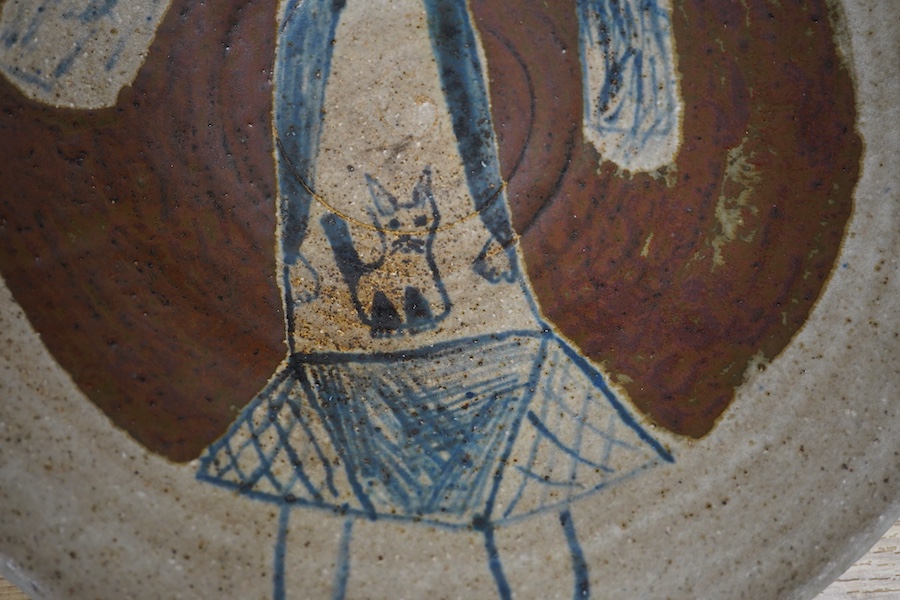 Eric James Mellon (1925-2014), a studio pottery dish, painted with a girl and cat, inscribed and dated 1971 to the foot rim, 29cm in diameter